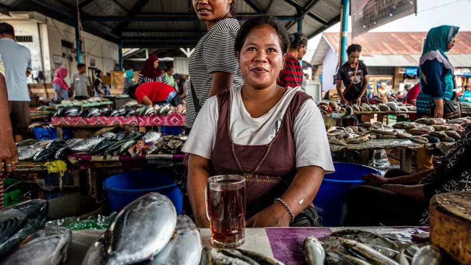 A woman stands in a stall selling fish in Langgur, Indonesia.