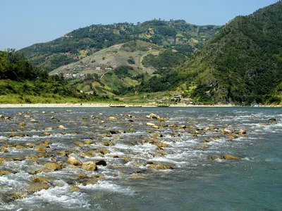 water flowing over rocks with mountains in the background