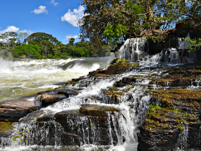 Augusto falls at Juruena, Brazil on a bright, sunny day. Water rushes down the waterfalls, creating rapid like water.