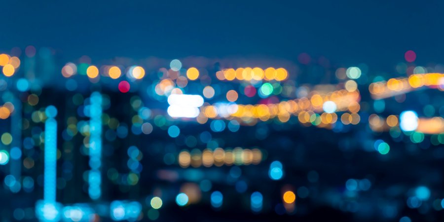 A blurry color photo with city lights in the distance