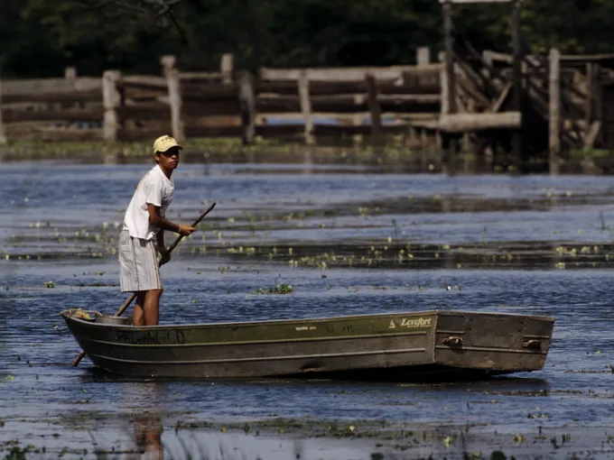 A boy in a flat boat in Pantanal, Brazil.