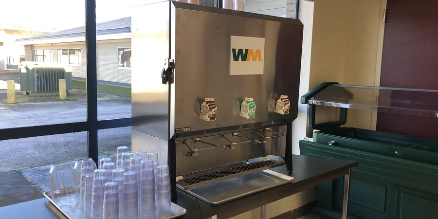 A bulk milk dispenser in a school cafeteria