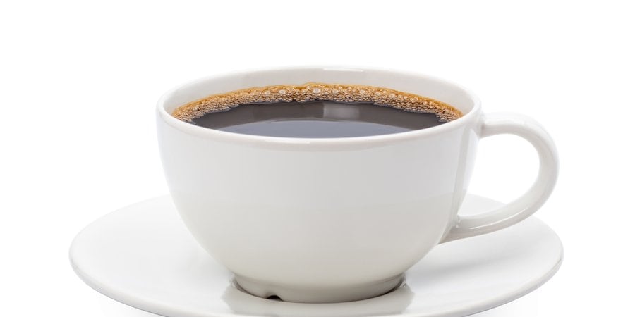 A cup of black coffee in a white cup and saucer