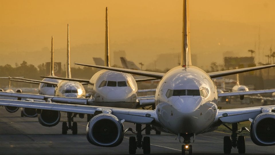 Airplanes in line to take off at sunset