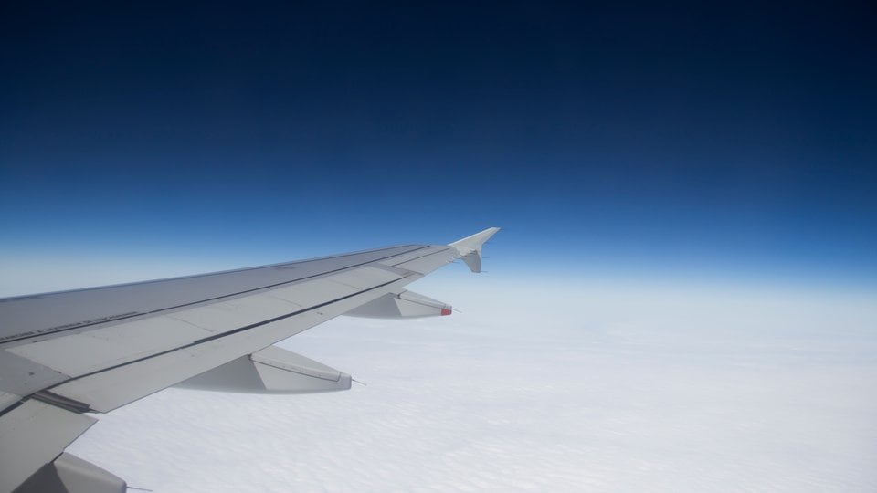Airplane wing against the background of clouds and sky