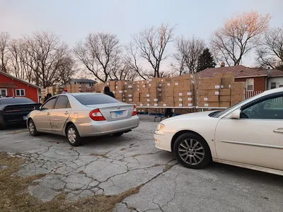 cars lined up in front of tables full of boxes