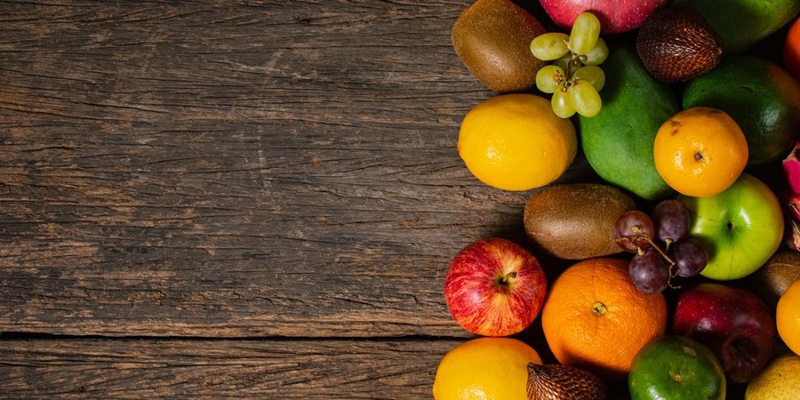 Fruits and vegetables placed on the right side of a wooden table