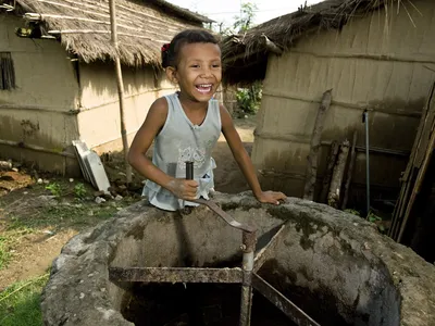 Surkhha Darai, age 5, turns the manure stirrer at her family home in the Bio-Gas Village.