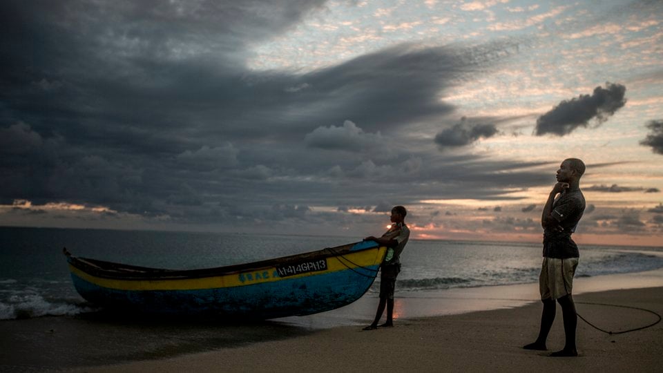 Two men with their boat on the beach in Mozambique