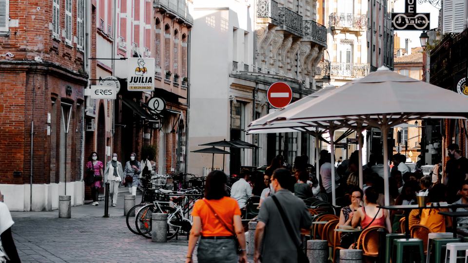 people eating outdoors on a street closed to traffic