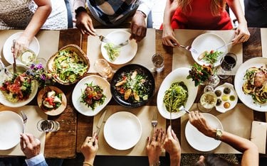 aerial shot of a group of people sitting around a table sharing a meal