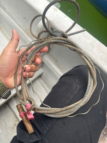 A person holds a recovered snare trap.