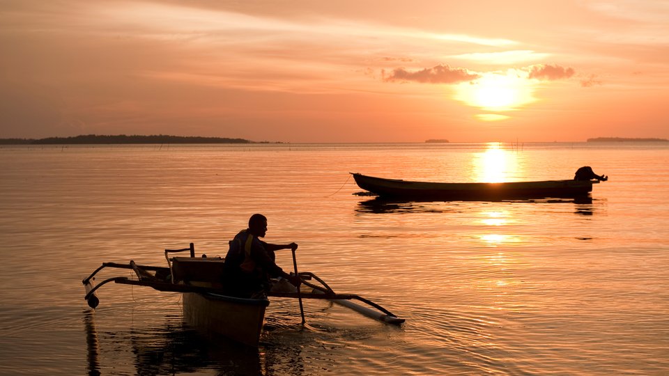 Fisherman in outrigger boats, sunset