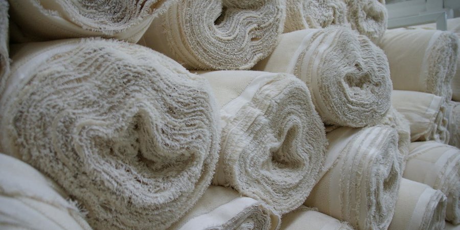 Stacks of rolled textile materials.