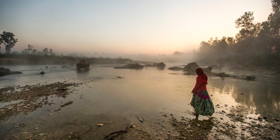 Woman walking through lake in Nepal