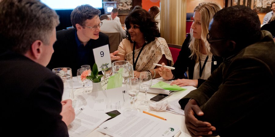 A group of people talk around a table