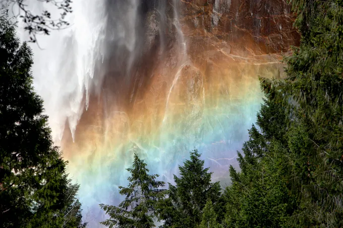 Light through waterfall creates rainbow